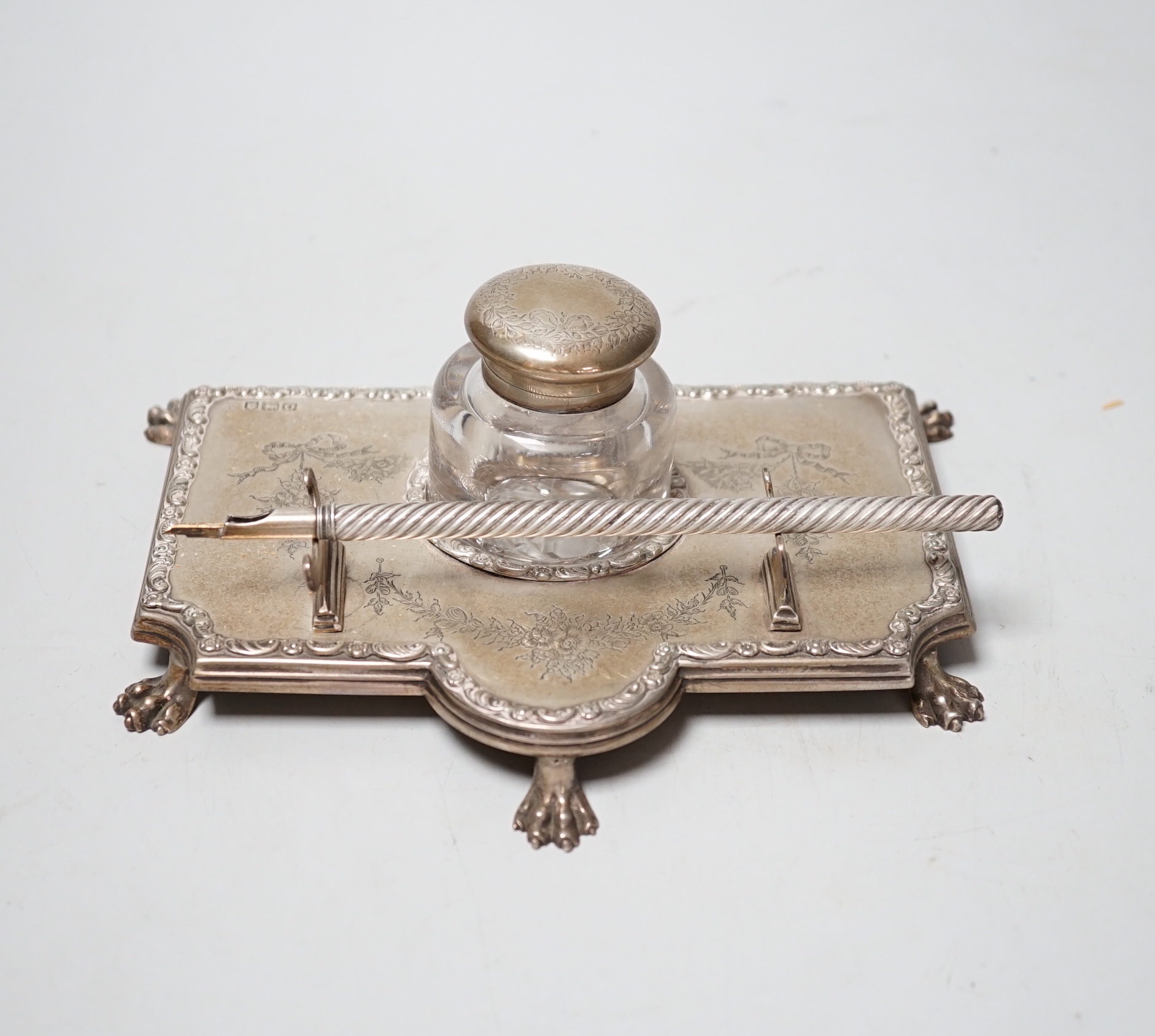 An Edwardian silver inkstand, with mounted glass well, on paw feet, maker's mark rubbed, London, 1909, 18.8cm, together with an associated S. Mordan & Co dip pen.